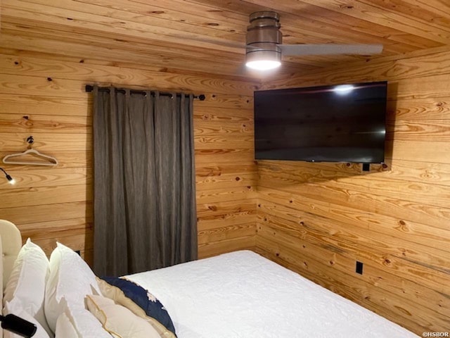 bedroom with wooden walls, wood ceiling, and a ceiling fan