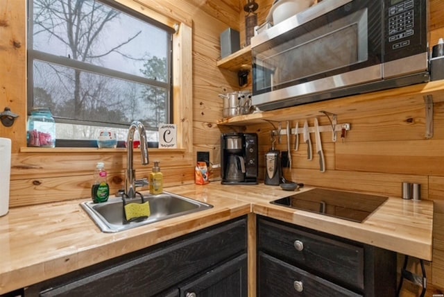 1136 Arlie Moore Rd, Bismarck, AR 71929 - kitchen with stainless steel microwave, wooden walls, wooden counters, a sink, and open shelves