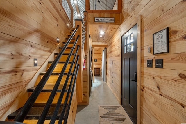 1136 Arlie Moore Rd, Bismarck, AR 71929 - corridor with stairway, wooden walls, finished concrete flooring, and a towering ceiling