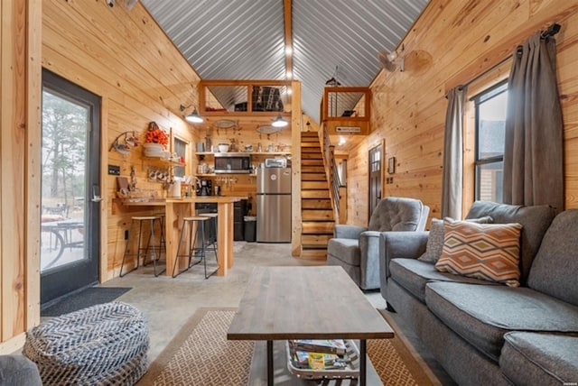 1136 Arlie Moore Rd, Bismarck, AR 71929 - living area featuring stairway, high vaulted ceiling, concrete floors, and wood walls