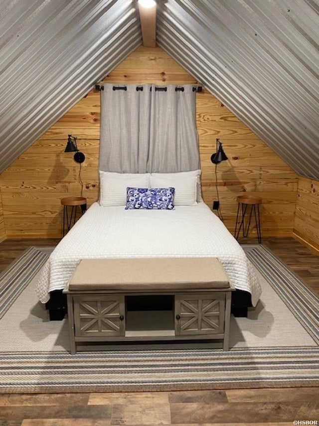 bedroom with lofted ceiling and wooden walls