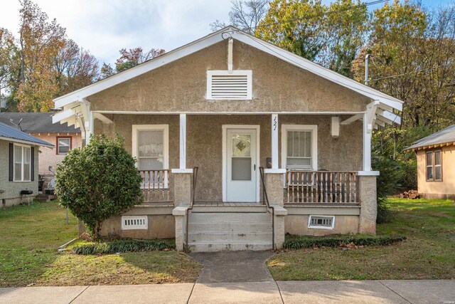 bungalow-style home featuring a porch and stucco siding