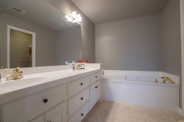 bathroom with a garden tub, tile patterned flooring, a sink, and visible vents