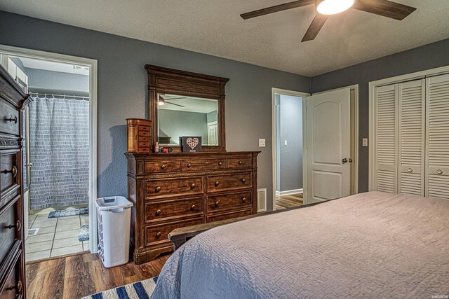 bedroom featuring a closet, visible vents, ceiling fan, connected bathroom, and wood finished floors