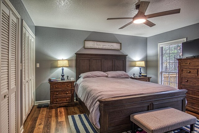 bedroom featuring a textured ceiling, dark wood-type flooring, and a textured wall