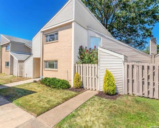 view of home's exterior with fence and a yard