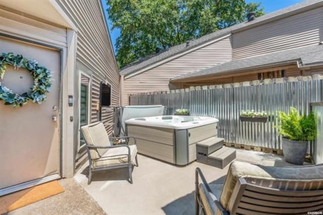 view of patio featuring fence and a hot tub