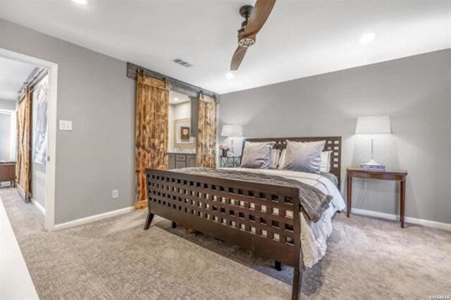 carpeted bedroom featuring a barn door, visible vents, baseboards, a ceiling fan, and recessed lighting