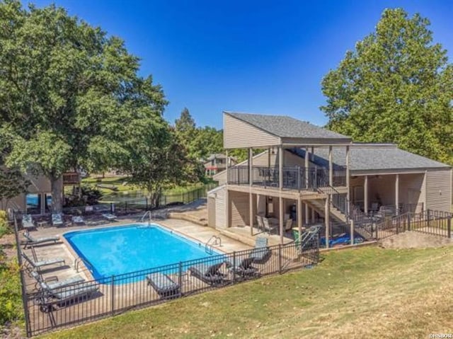 pool with a deck, a patio, fence, stairs, and a lawn