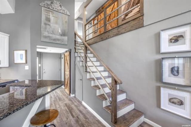 stairway with baseboards and wood finished floors