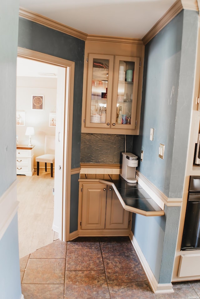 kitchen featuring baseboards, glass insert cabinets, tile counters, and oven