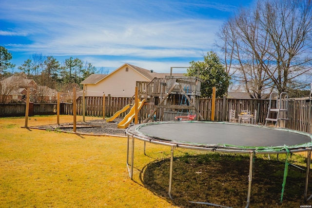 view of play area with a trampoline, a fenced backyard, and a lawn