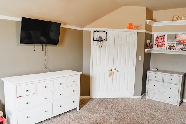 bedroom featuring a closet, light colored carpet, and vaulted ceiling