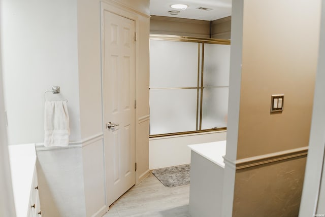 full bathroom featuring an enclosed shower, vanity, and wood finished floors