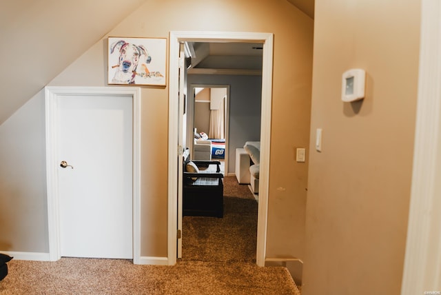 corridor featuring vaulted ceiling and carpet flooring