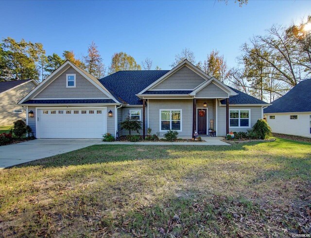 view of front of property featuring driveway, an attached garage, and a front lawn