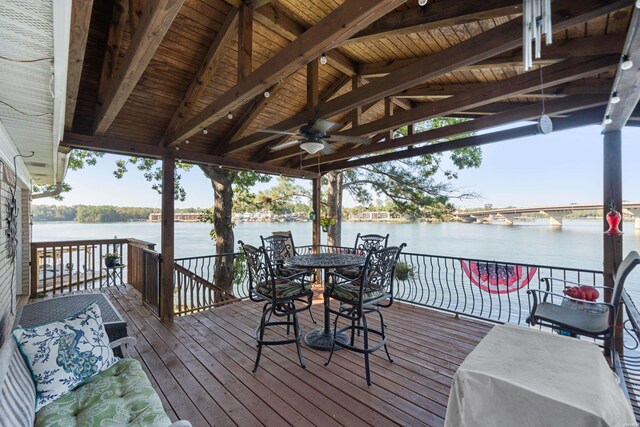 deck with a water view and ceiling fan