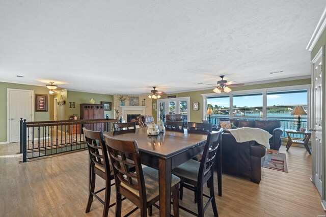 dining space featuring light wood-style floors, a textured ceiling, and a wealth of natural light