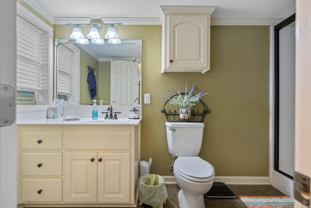 bathroom featuring tile patterned flooring, toilet, vanity, baseboards, and crown molding