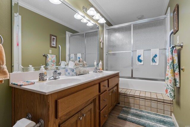 full bath featuring double vanity, crown molding, enclosed tub / shower combo, and a sink