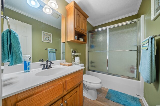 full bathroom featuring ornamental molding, wood finished floors, vanity, and bath / shower combo with glass door