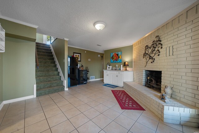 unfurnished living room featuring crown molding, a fireplace, light tile patterned floors, visible vents, and stairway