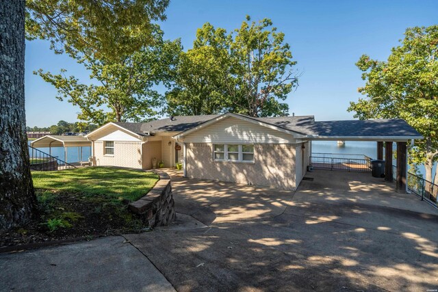 single story home featuring concrete driveway, brick siding, a front yard, and fence