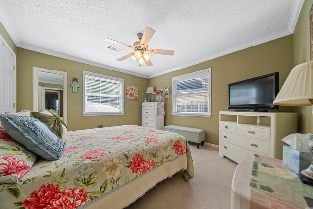 bedroom with crown molding, light colored carpet, visible vents, ceiling fan, and a textured ceiling