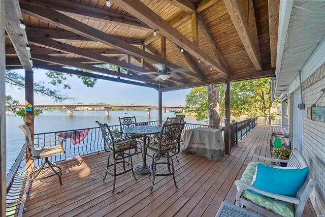 wooden deck with a water view and ceiling fan