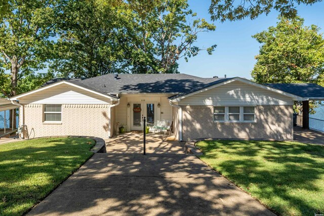 ranch-style home featuring a front lawn and brick siding