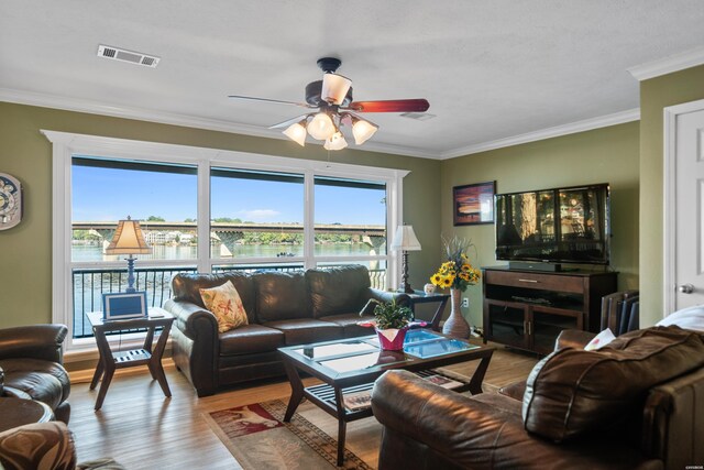 living room with visible vents, radiator, ceiling fan, ornamental molding, and light wood-type flooring