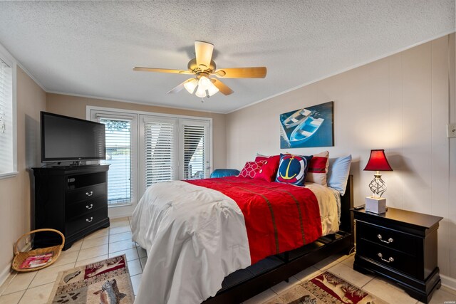 bedroom with light tile patterned floors, a textured ceiling, a ceiling fan, and crown molding