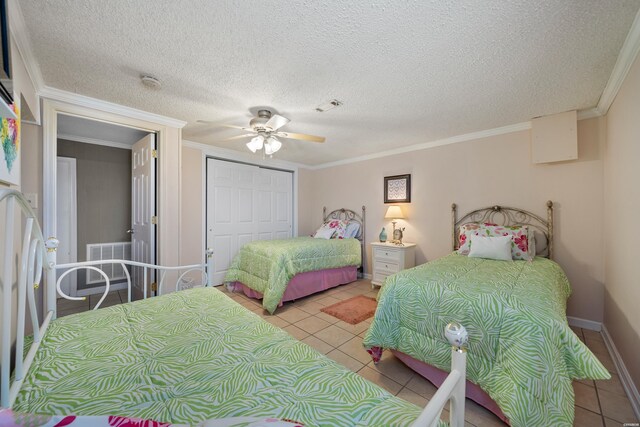 bedroom featuring a closet, visible vents, crown molding, and light tile patterned flooring