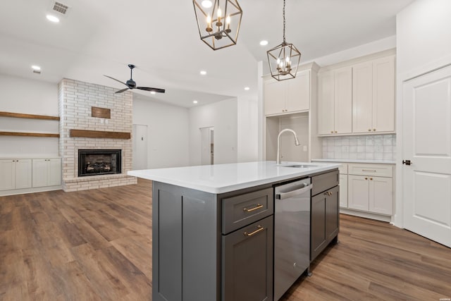 kitchen featuring a sink, ceiling fan with notable chandelier, dishwasher, white cabinets, and visible vents