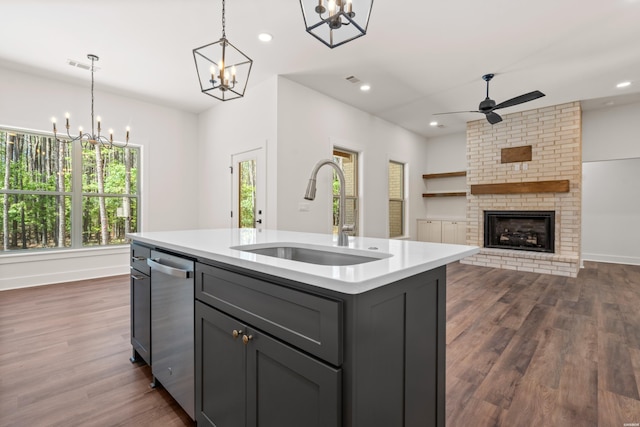 kitchen with a sink, light countertops, dishwasher, gray cabinets, and a fireplace