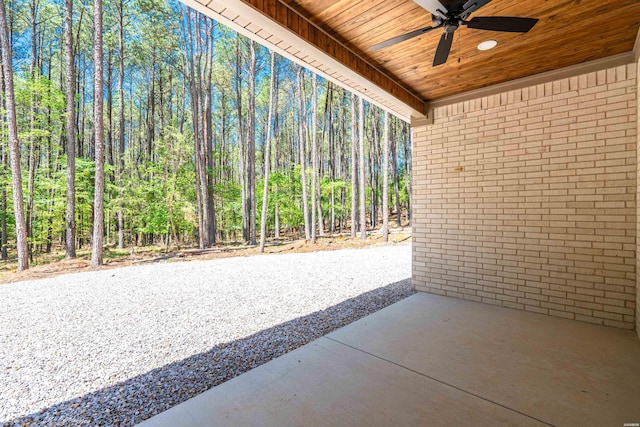 view of patio / terrace featuring a forest view and ceiling fan