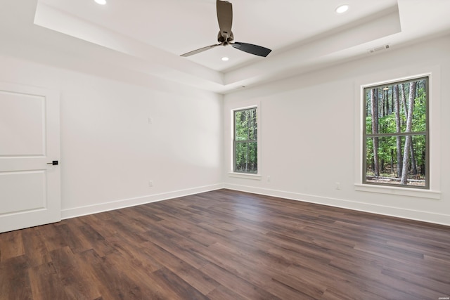 unfurnished room featuring recessed lighting, a raised ceiling, a ceiling fan, baseboards, and dark wood-style flooring