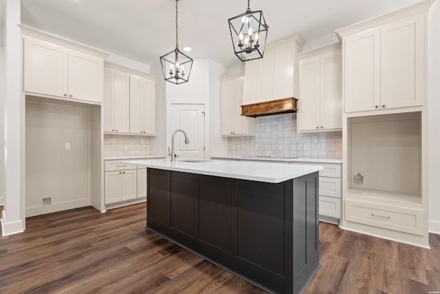 kitchen featuring a sink, an island with sink, backsplash, a notable chandelier, and recessed lighting