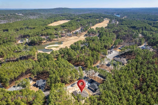 drone / aerial view featuring a water view and a wooded view