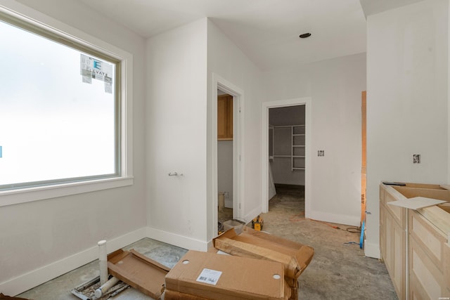 bedroom with a spacious closet, baseboards, and a closet