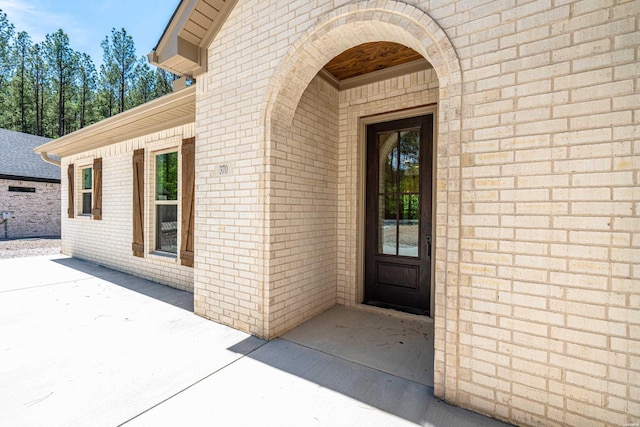 entrance to property featuring brick siding