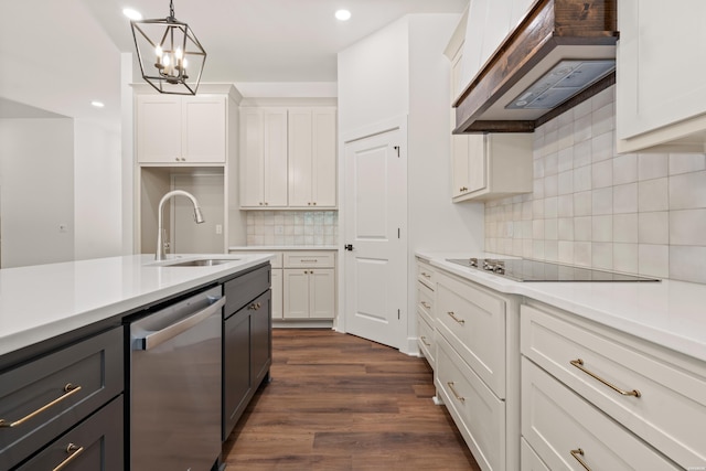 kitchen with stainless steel dishwasher, a sink, white cabinetry, wall chimney range hood, and black electric stovetop