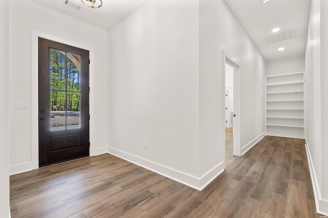 foyer featuring baseboards, wood finished floors, visible vents, and recessed lighting