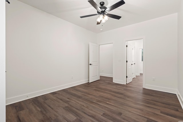 unfurnished bedroom featuring dark wood-type flooring, a ceiling fan, and baseboards