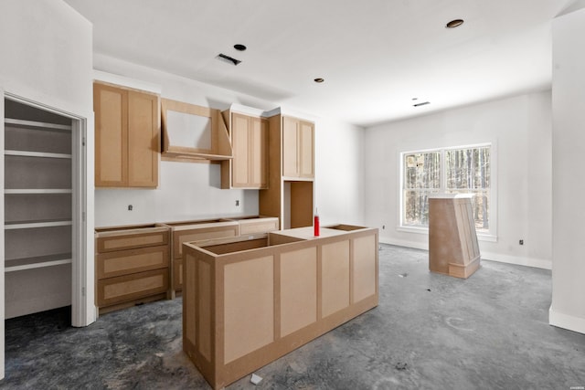 kitchen with baseboards, unfinished concrete floors, a center island, wall chimney range hood, and light brown cabinets