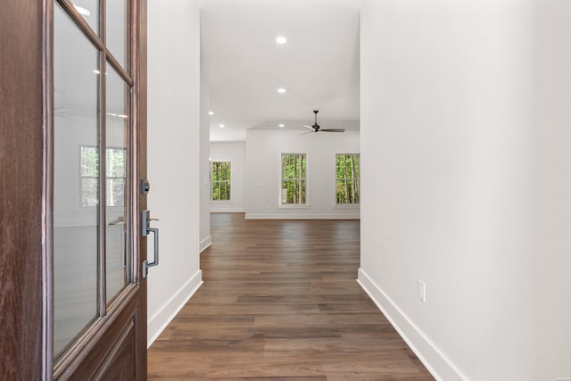 hall featuring baseboards, recessed lighting, and dark wood finished floors