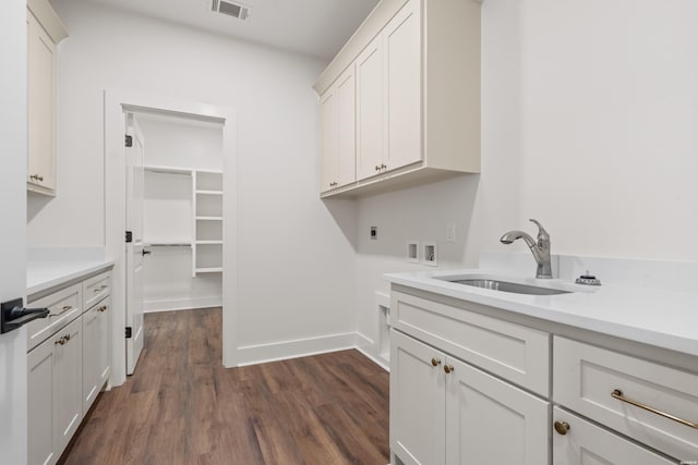 clothes washing area featuring hookup for a washing machine, a sink, hookup for an electric dryer, cabinet space, and visible vents