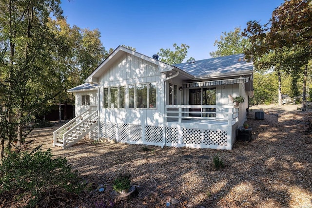 back of property featuring stairs and cooling unit