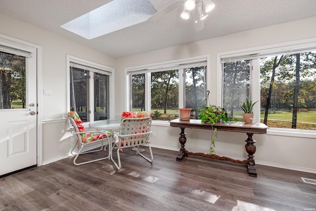 sunroom / solarium featuring a skylight, ceiling fan, visible vents, and a wealth of natural light