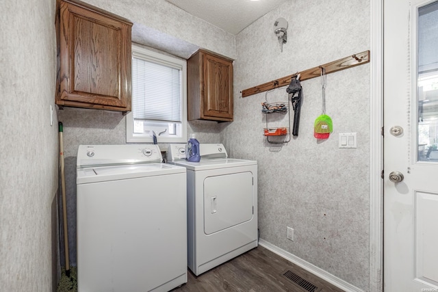 laundry area featuring cabinet space, baseboards, washer and clothes dryer, and dark wood finished floors